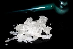 pile of meth crystals and a meth pipe